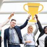 group holding paper trophy