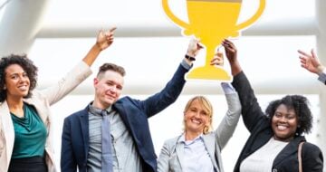 group holding paper trophy