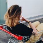 woman sitting on shopping cart